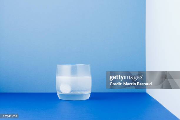 vaso de agua con un comprimido en la disolución - comprimido efervescente fotografías e imágenes de stock
