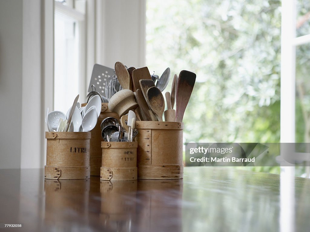Küchengeräte in Containern auf Tisch
