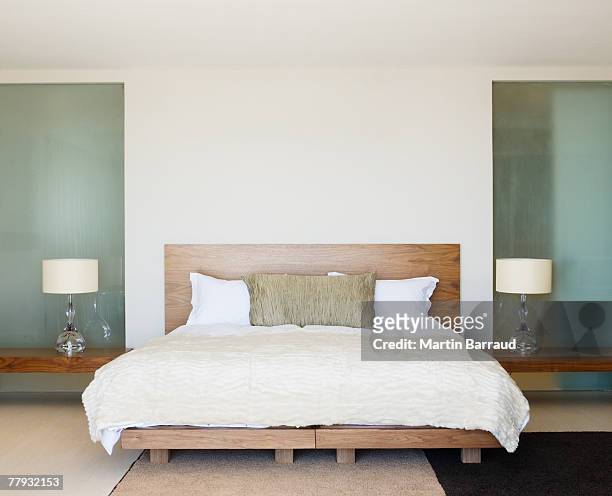 modern double bed with bedside tables - slaapkamer stockfoto's en -beelden