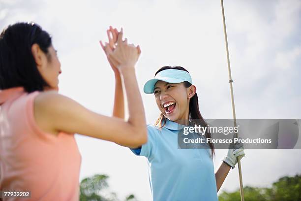 two women playing golf - women golf stock pictures, royalty-free photos & images