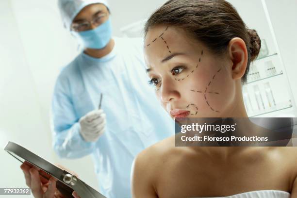 woman with plastic surgery lines drawn on face - schönheitsoperation stock-fotos und bilder