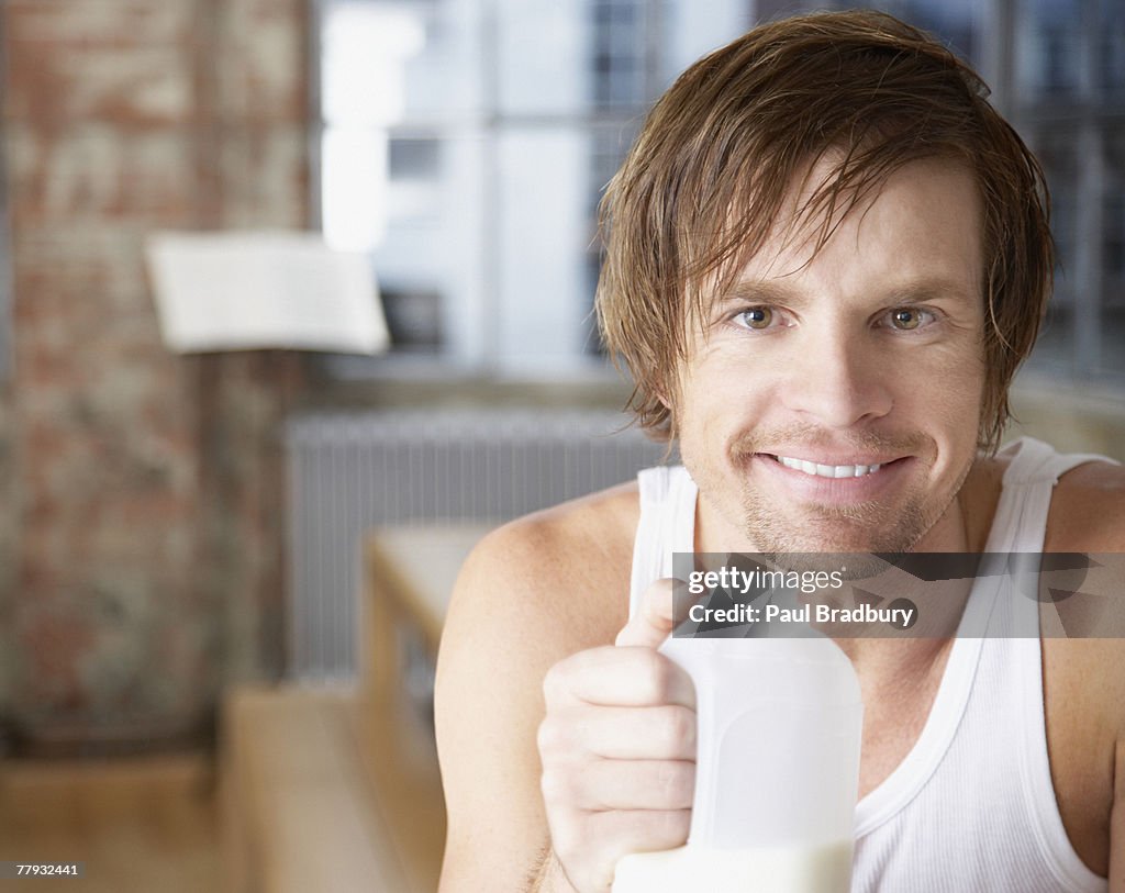 Uomo con Bricco del latte in casa moderna