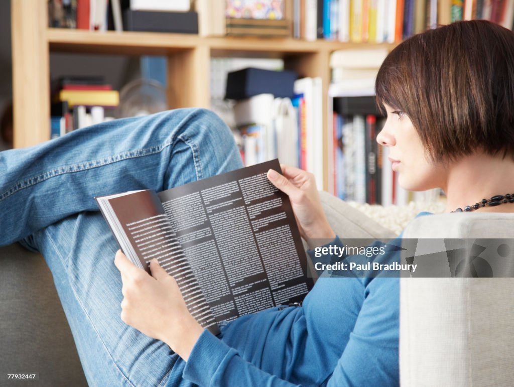 Woman lying in chair reading