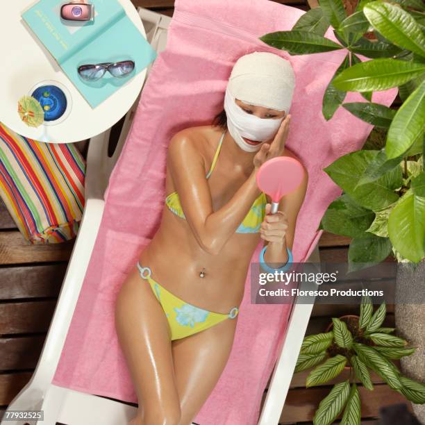 woman in swimwear with face wrapped in gauze - chirurgia estetica donna foto e immagini stock