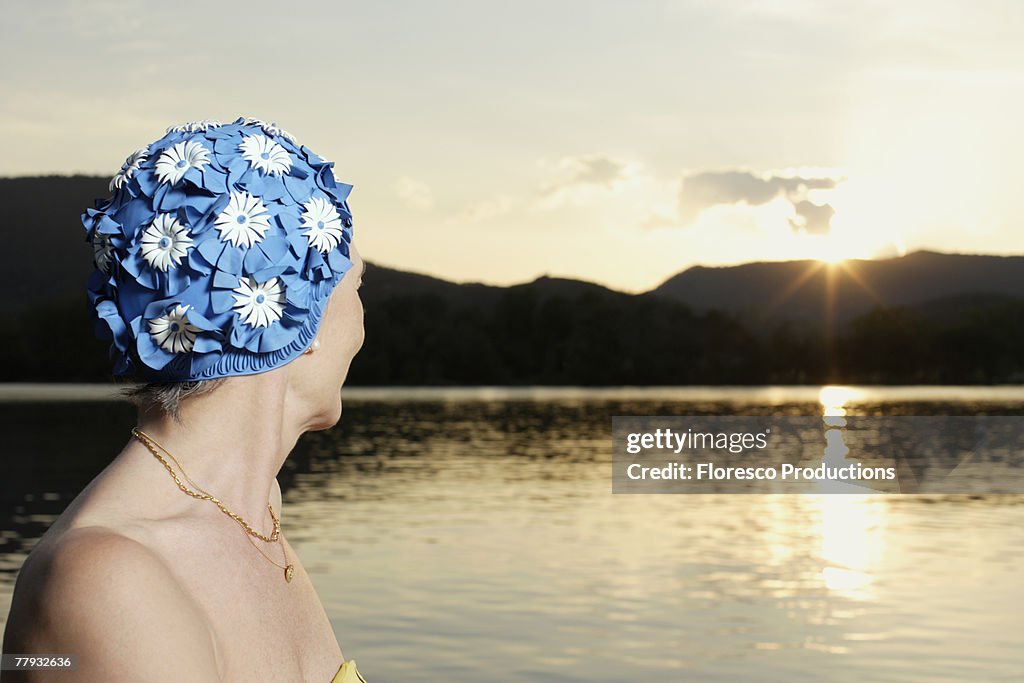 Woman wearing swim cap outdoors by lake