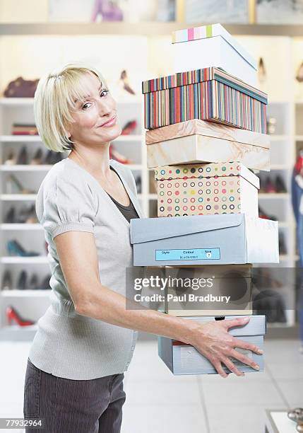 woman carrying stack of shoe boxes in store - shoe boxes stock pictures, royalty-free photos & images