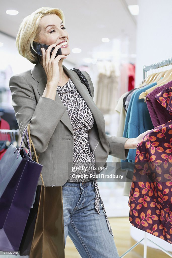 Frau shopping, während auf Mobiltelefonen