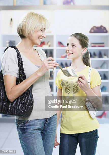 woman and girl looking at shoes in store - tween heels stock pictures, royalty-free photos & images