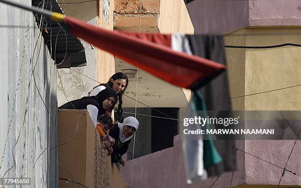 Palestinian women lean to look out from their balcony in the Burj al-Barajneh refugee camp in Beirut, 16 November 2007. Three Palestinians were...