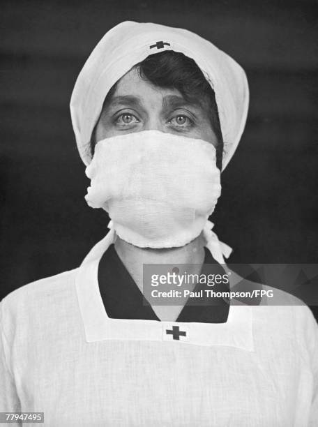 The use of a facemask by Red Cross personnel in the United States helps decrease the spread of the disease, circa 1918.