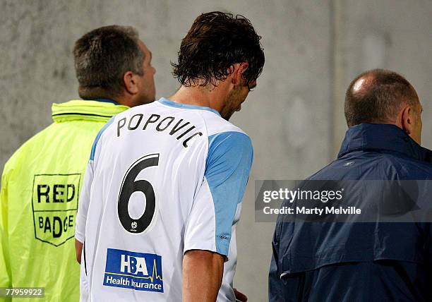 Sydney FC captain Tony Popovic is lead off of the field after getting a red card from match referee Peter Green during the round 13 A-League match...