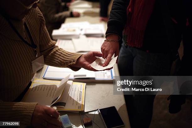 An Ethnic Albanian gets her finger sprayed to detect if she has already cast her vote in the parliamentary election at a polling station on November...