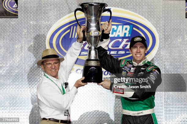 Team owner Jack Roush and Carl Edwards, driver of the Scotts Ford, hold up the NASCAR Busch Series Championship trophy following the Ford 300 at...