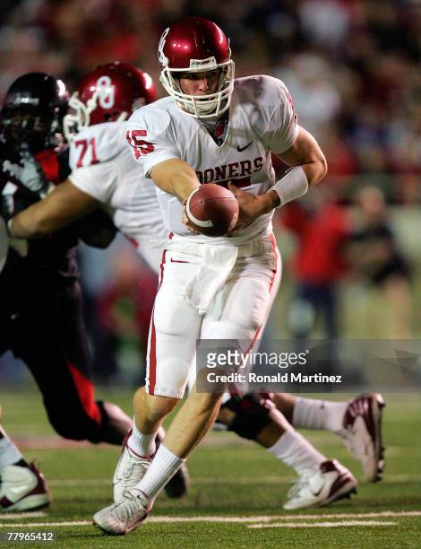 Quarterback Joey Halzle of the Oklahoma Sooners hands the ball off against the Texas Tech Red Raiders in the first quarter at Jones AT&T Stadium on...