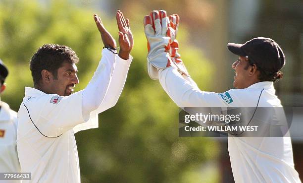 Sri Lankan spinner Muttiah Muralitharan is congratulated by teammate Prasanna Jayawardene after dismissing Australian batsman Matthew Hayden during...