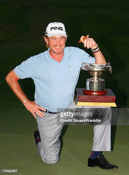 Miguel Angel Jimenez of Spain celebrates with the trophy and a cigar after winning the UBS Hong Kong Open at the Hong Kong Golf Club on November 18,...