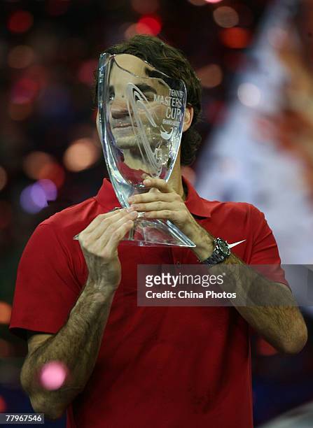 Roger Federer of Switzerland displays the trophy after he beat David Ferrer of Spain in the final match of the Tennis Masters Cup at Qi Zhong Stadium...