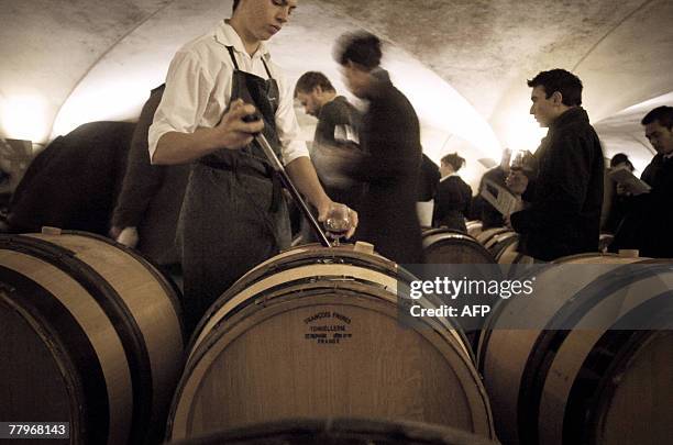 Un caviste pr?l?ve du vin d'un f?t avant de servir un verre, le 18 novembre 2007 dans une cave des Hospices de Beaune, lors d'une d?gustation ouverte...