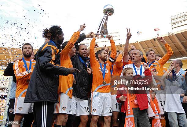 Wade Barrett of the Houston Dynamo holds up the trophy in celebration with his team after defeating the New England Revolution by a score of 2-1 to...