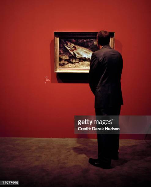 American artist Jeff Koons examines the Gustave Courbet painting, the "La Truite" at the opening of the 19th century French painter's exhibition on...