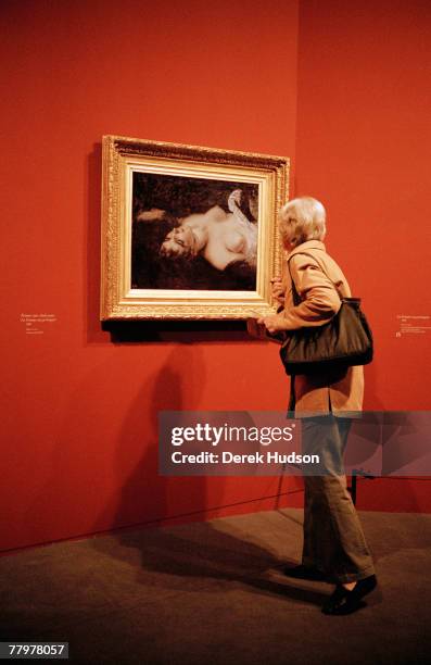 Member of the public examines the Gustave Courbet painting "Femme nue, etude pour la femme au perroquet" , owned by American artist Jeff Koons, at...