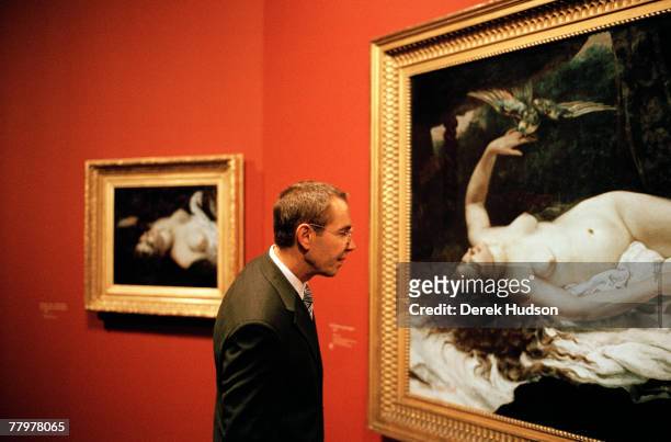 American artist Jeff Koons examines the Gustave Courbet painting, "La Femme au Perroquet" from 1866, of which he owns the smaller study to the left...