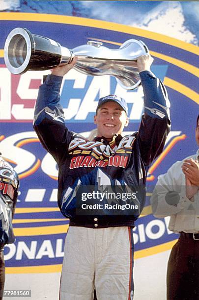 Kevin Harvick celebrates with his 2001 NASCAR Busch Series championship trophy.