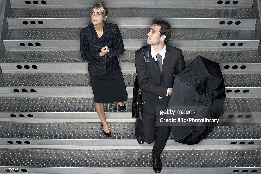 Two business people entering a train station