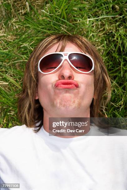 male lying on grass wearing sunglasses pouting - pursed stock pictures, royalty-free photos & images