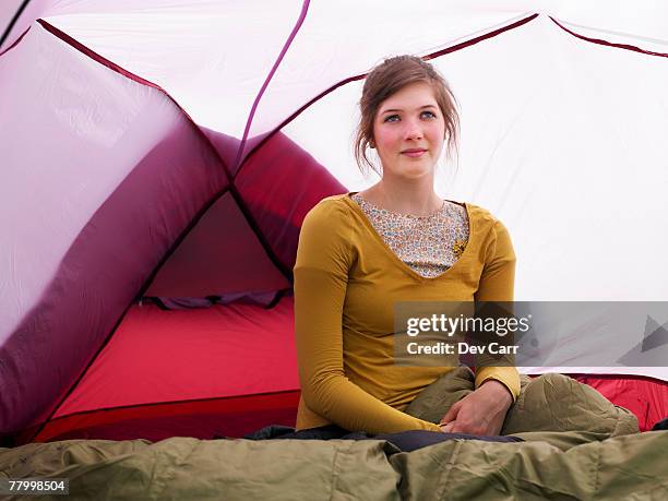 girl sitting in sleeping bag in pink tent - festival camping stock pictures, royalty-free photos & images
