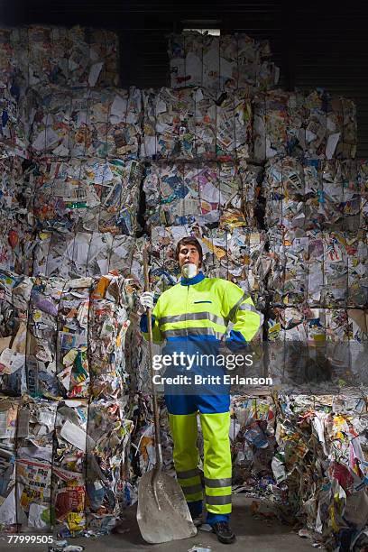 man standing in front of a wall of recycling. - vuilnisman stockfoto's en -beelden