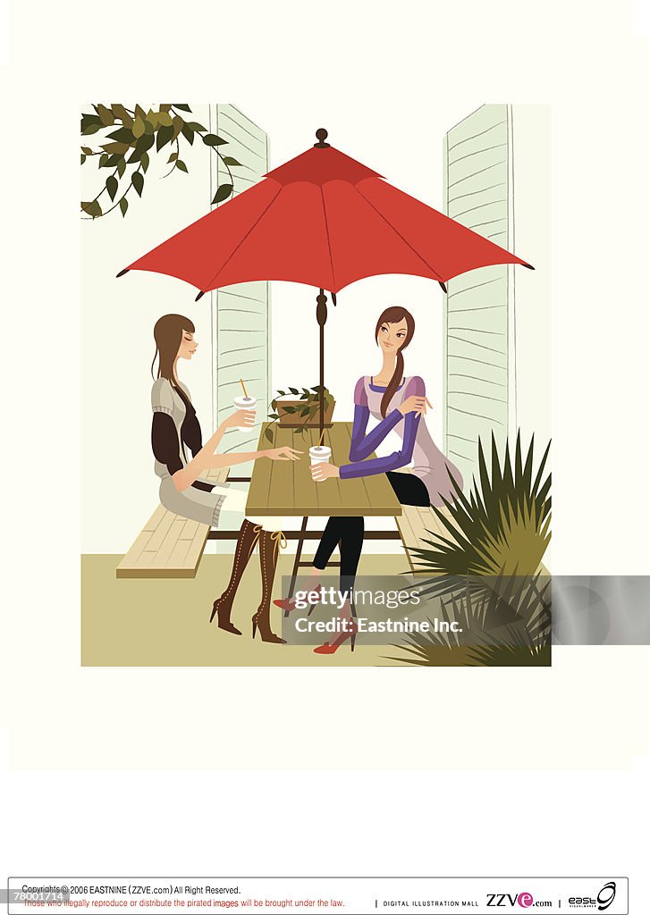 Two women sitting at a sidewalk cafe
