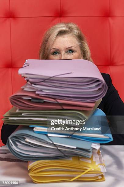 businesswoman working at a table with red seating - une seule femme d'âge mûr photos et images de collection