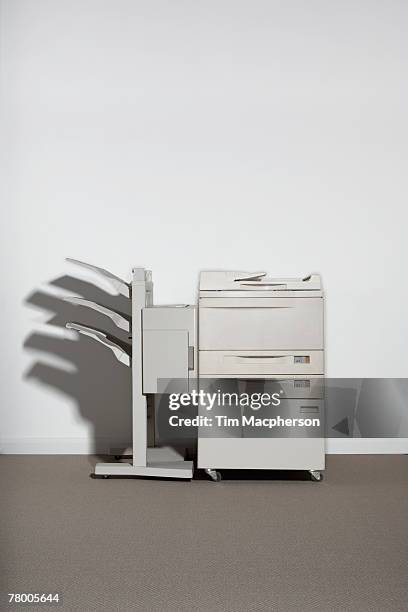 a photocopier against a white wall. - copying bildbanksfoton och bilder