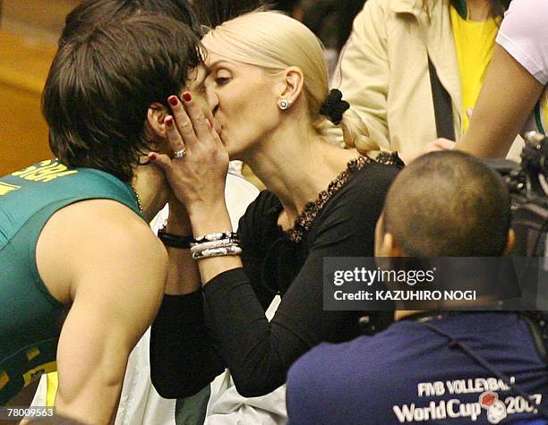 Brazilian volleyball star Gilberto Godoy Filho "Giba" kisses his wife after their match of the FIVB Men's World Cup volleyball tournament against...