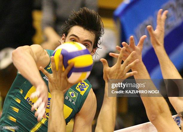 Brazilian volleyball star Gilberto Godoy Filho "Giba" smashes the ball against Egyptian players during a match of the FIVB Men's World Cup volleyball...