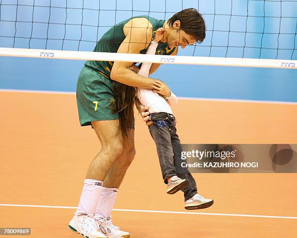 Brazilian volleyball star Gilberto Godoy Filho "Giba" and his daughter play on the court after a match of the FIVB Men's World Cup volleyball...