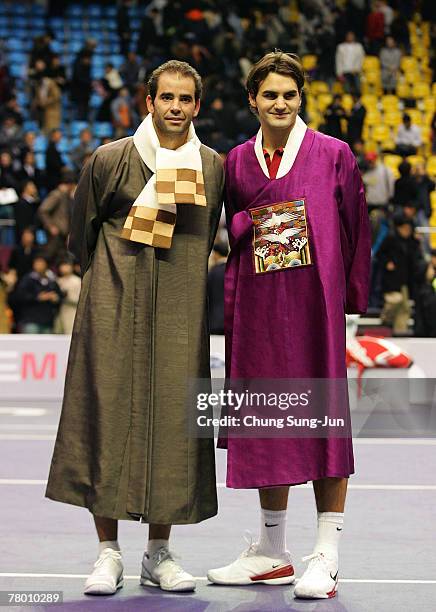 Pete Sampras of USA and Roger Federer of Switzerland, wearing South Korean traditional robes, pose together after playing the invitational exhibition...