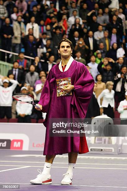 Roger Federer of Switzerland, wearing a South Korean traditional robe, celebrates after defeating Pete Sampras of USA by a score of 6-4, 6-3 to win...