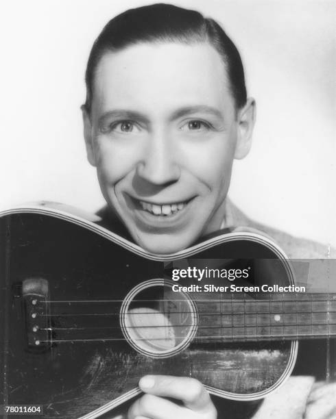 English singer, actor and comedian George Formby with his trademark ukulele, circa 1938.