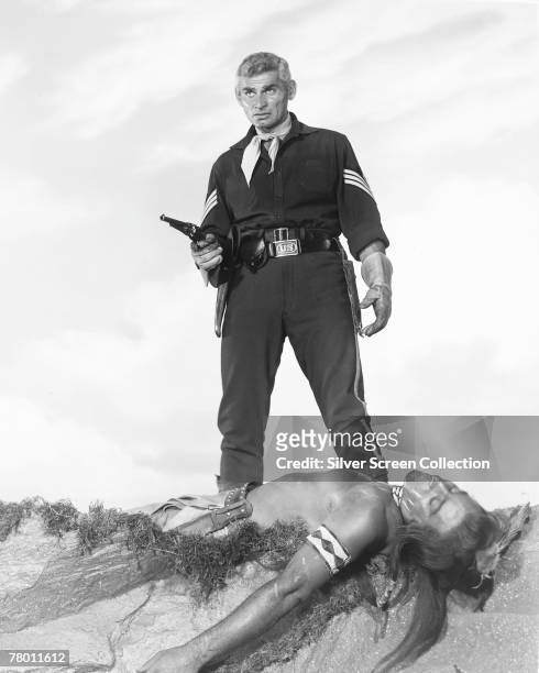 American actor Jeff Chandler stands over the dead body of a Native American in his role as First Sergeant Emmett Bell of the US Cavalry in the...