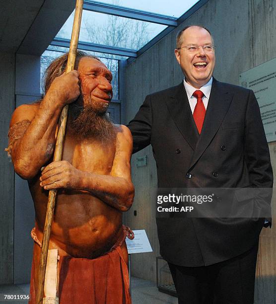 German Finance minister Peer Steinbrueck laughs as he poses next to a reconstruction of a Neanderthal Man as he visits the Neanderthalmuseum in...
