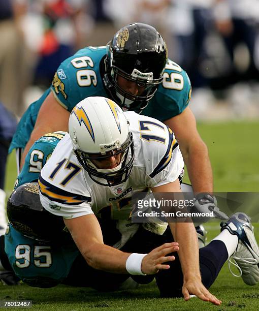 Philip Rivers of the San Diego Chargers is sacked by Paul Spicer and Derek Landiri of the Jacksonville Jaguars at Jacksonville Municipal Stadium on...