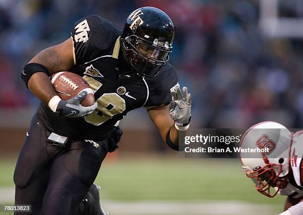 Fullback De'Angelo Bryant of the Wake Forest Demon Deacons tries to avoid DaJuan Morgan of the North Carolina State Wolfpack at BB&T Field November...