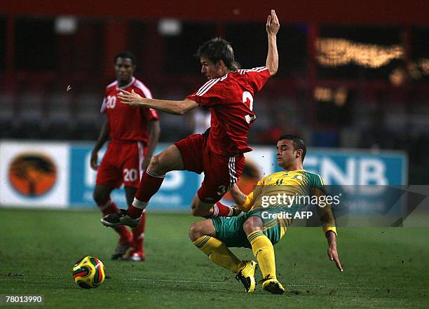 Canada's Mine Klukowski is tackled by South Africa Lance Davids during their football match held at the ABSA Stadium in Durban, 20 November 2007....