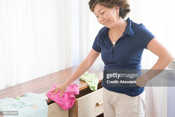 woman getting upset at mess over chest - chest of drawers 個照片及圖片檔