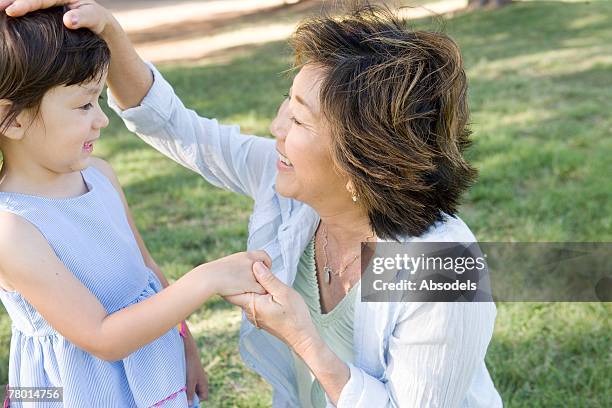 grandmother ruffling girl's hair - ruffling stock pictures, royalty-free photos & images