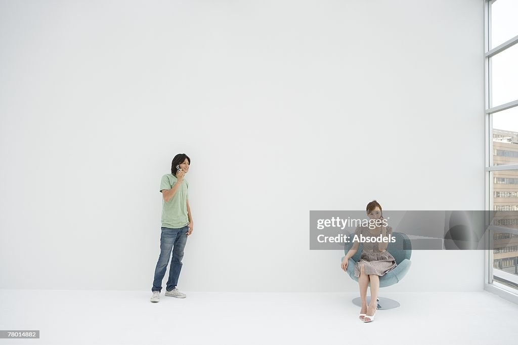 A man and a woman talking on cell phones