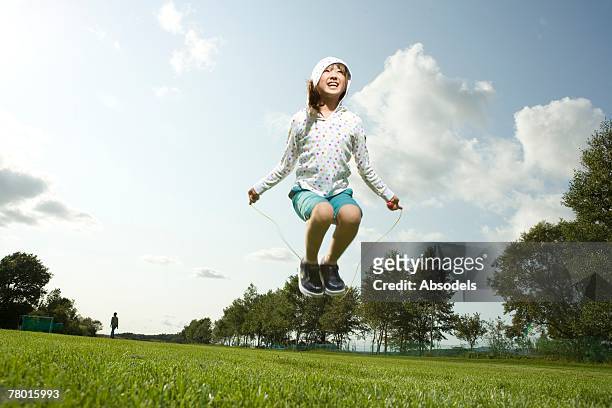 young girl skipping in grass - 縄跳びの縄 ストックフォトと画像