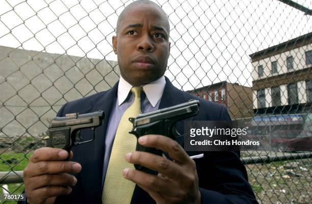 Eric Adams, a lieutenant in the New York Police Department and co-founder of 100 Black Men in Law Enforcement organization, holds up a toy gun, left,...